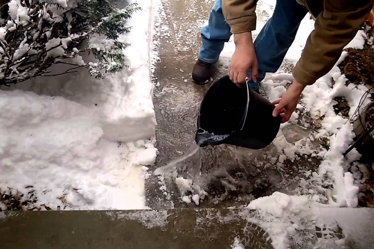 Bucket of Water Pouring On Icy Sidewalk