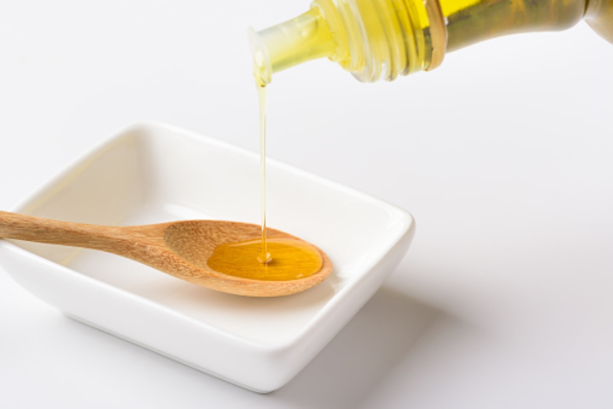 Olive Oil Poured Onto Wooden Spoon