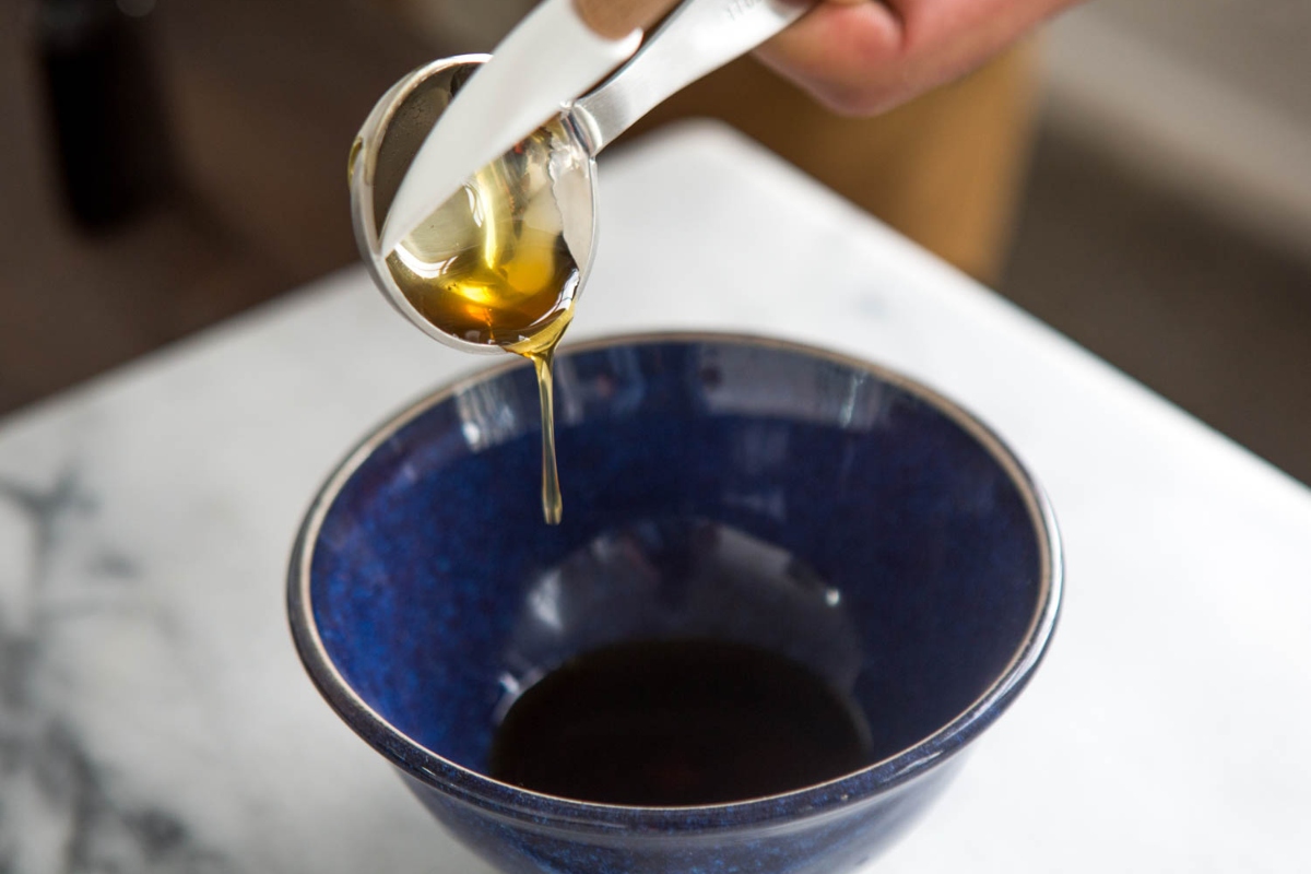 Scooping Honey Out Of Measuring Cups